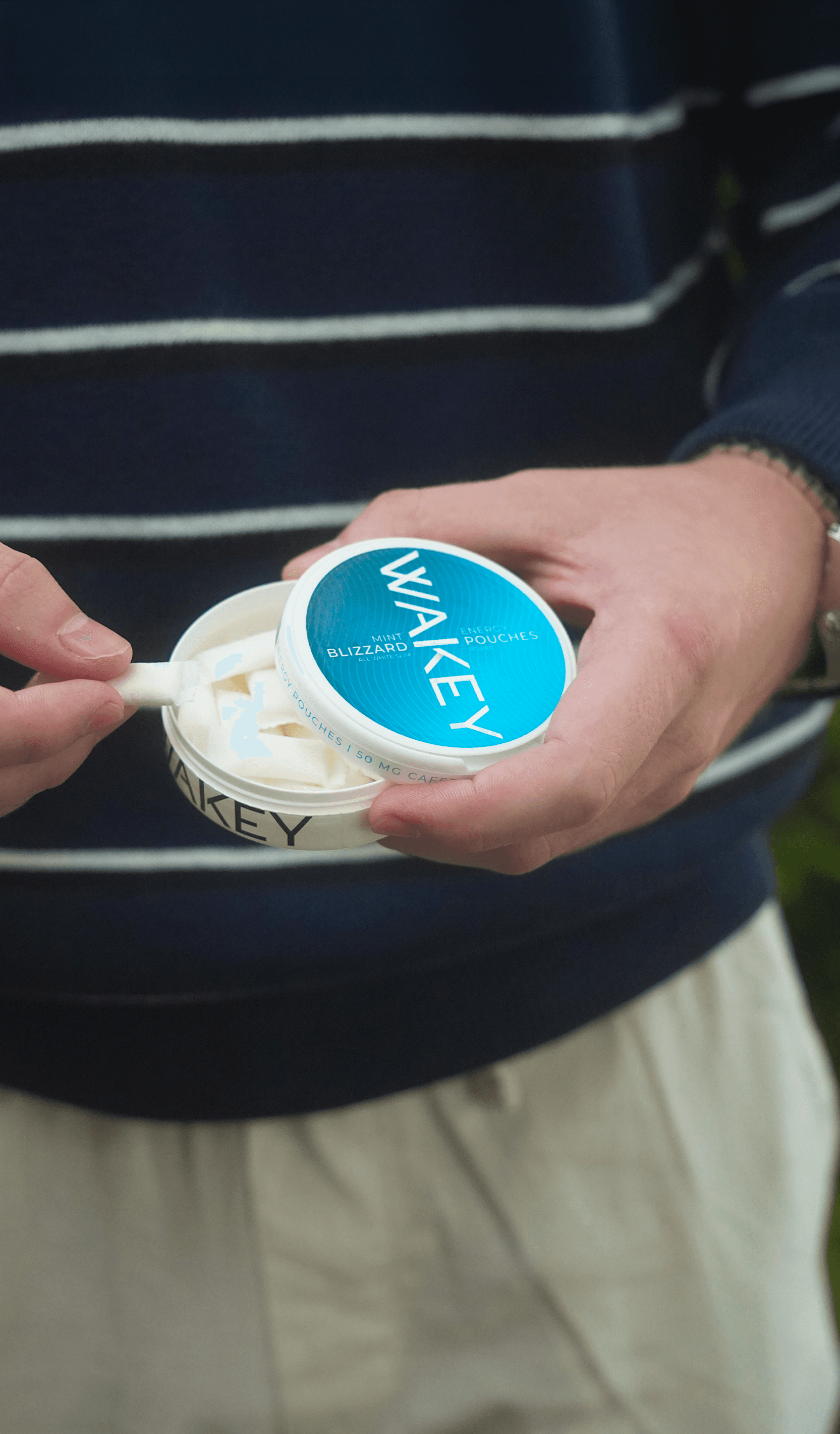 Hands opening a Wakey Blizzard Mint tin