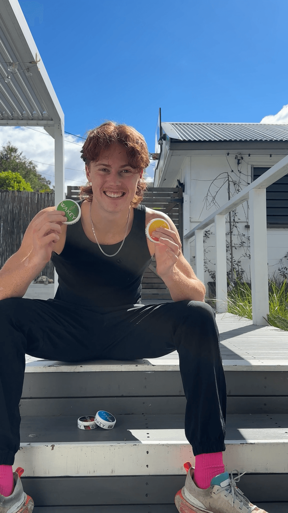 Man outdoors holding two Wakey tins